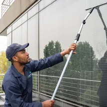 Cleaner washing large office windows from outside