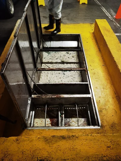 Open grease trap chambers being serviced and cleaned at a shopping centre