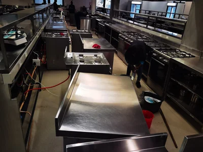 Cleaner degreasing stoves and stainless steel counters in an industrial kitchen