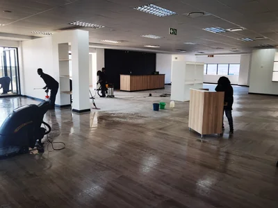Team scrubbing an LVT showroom floor using a walk-behind scrubber drier